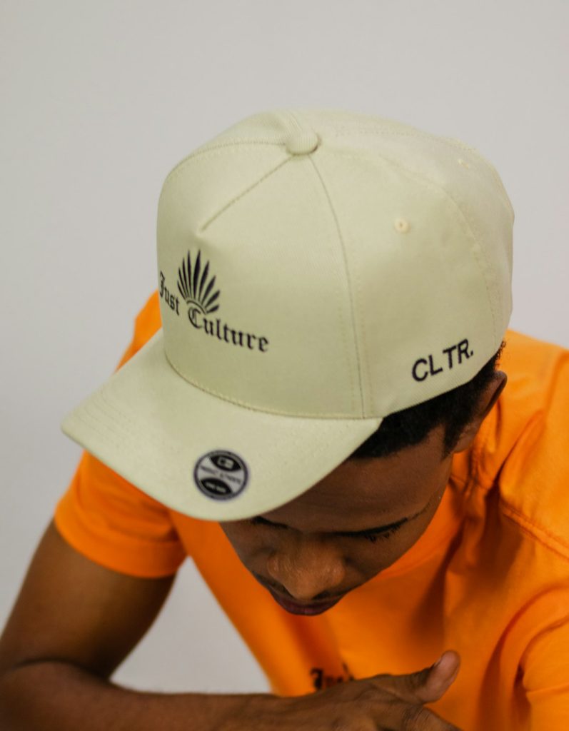 a-man-wearing-an-orange-shirt-and-a-white-hat-8elaprkczew
